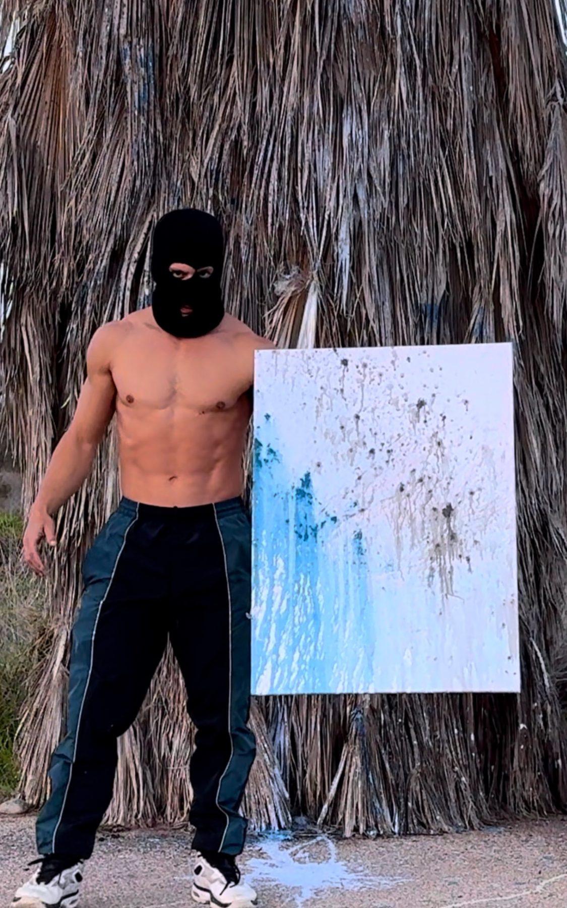 Alejandro Sánchez, masked, beside Bullet Rain at the palm tree in southern Spain where it was painted